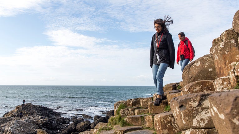 Two female visitors standing on the rocks at Giant's Causeway, County Antrim